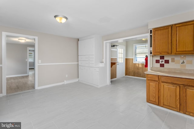 16 Woodside Ln, Keansburg, NJ 07734 - kitchen with brown cabinets, light countertops, a wainscoted wall, and baseboards
