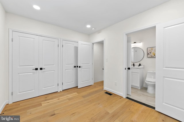 713 Tewkesbury Pl NW, Washington, DC 20012 - unfurnished bedroom with two closets, light wood-style flooring, connected bathroom, baseboards, and recessed lighting