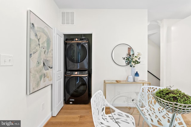713 Tewkesbury Pl NW, Washington, DC 20012 - laundry room with stacked washer and clothes dryer and light wood-type flooring