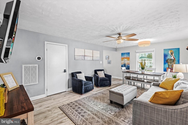 412 Marshall Ave, Colonial Beach, VA 22443 - living area featuring wood finished floors, a textured ceiling, a ceiling fan, and baseboards