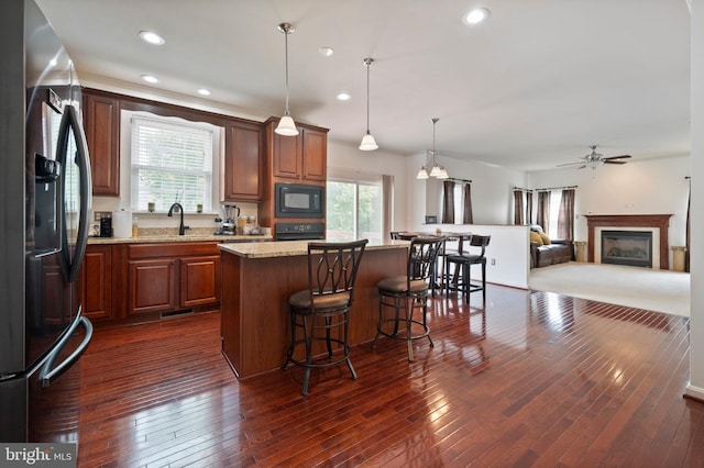 2652 Academic Ct, Waldorf, MD 20603 - kitchen with black appliances, plenty of natural light, a kitchen island, a breakfast bar, and recessed lighting