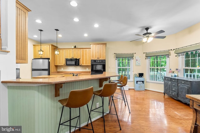 240 Charleston Rd, Ocean Pines, MD 21811 - kitchen with black appliances, plenty of natural light, a peninsula, light brown cabinets, and recessed lighting