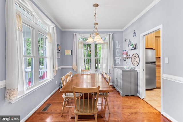 240 Charleston Rd, Ocean Pines, MD 21811 - dining area featuring plenty of natural light, a chandelier, ornamental molding, and light wood-type flooring