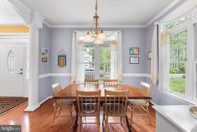 240 Charleston Rd, Ocean Pines, MD 21811 - dining area featuring plenty of natural light, decorative columns, wood finished floors, a chandelier, and crown molding