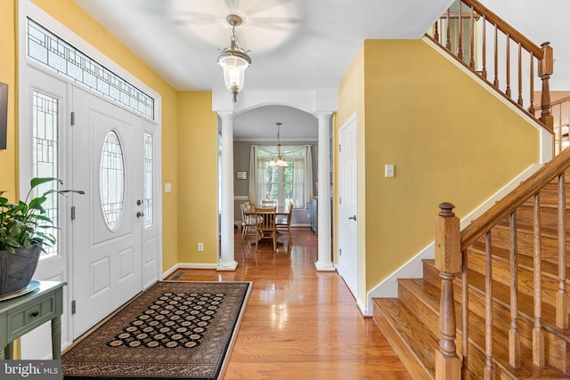 240 Charleston Rd, Ocean Pines, MD 21811 - foyer entrance with ornate columns, stairs, light wood-style flooring, and arched walkways