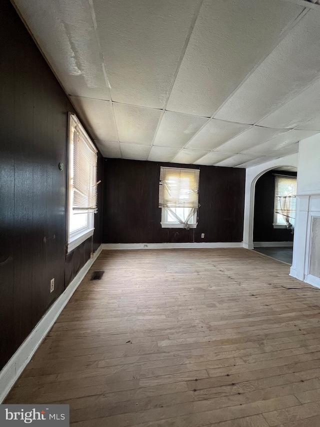 309 Marshall St, Salisbury, MD 21804 - unfurnished room with baseboards, wood-type flooring, arched walkways, and wood walls