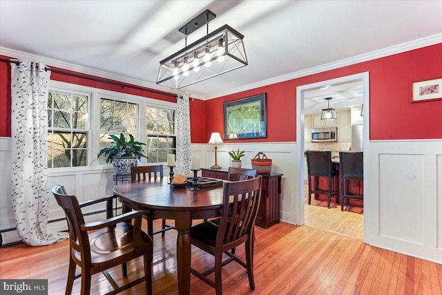601 Crum Creek Rd, Media, PA 19063 - dining space with ornamental molding, a decorative wall, light wood-type flooring, a wainscoted wall, and a chandelier
