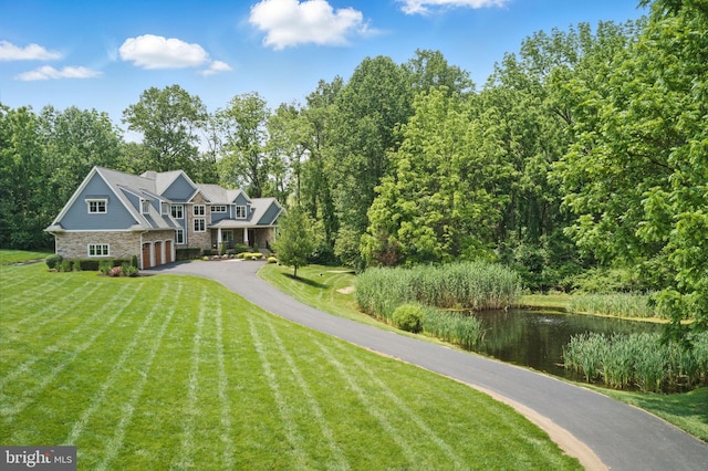 415 Pyles Mountain Ln, Avondale, PA 19311 - view of front of house with driveway, stone siding, an attached garage, a front yard, and a water view