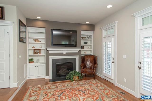 2105 Avinity Loop, Charlottesville, VA 22902 - living area featuring wood finished floors, a glass covered fireplace, recessed lighting, baseboards, and built in features
