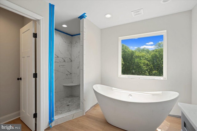 7016 Grace Landing Ct, Hughesville, MD 20637 - full bath featuring a soaking tub, wood finished floors, baseboards, a marble finish shower, and vanity