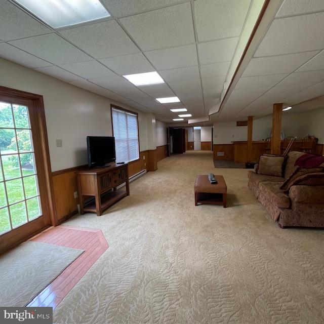 1359 Michael Way, Lansdale, PA 19446 - living room with a paneled ceiling, wainscoting, wooden walls, a baseboard radiator, and light carpet
