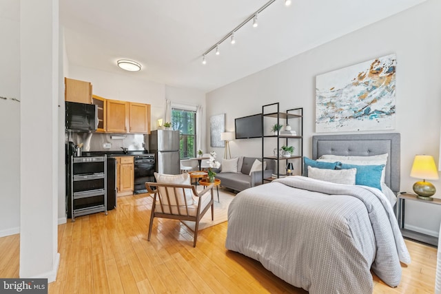 1822 15th St NW Unit 305, Washington, DC 20009 - bedroom with freestanding refrigerator, track lighting, and light wood finished floors