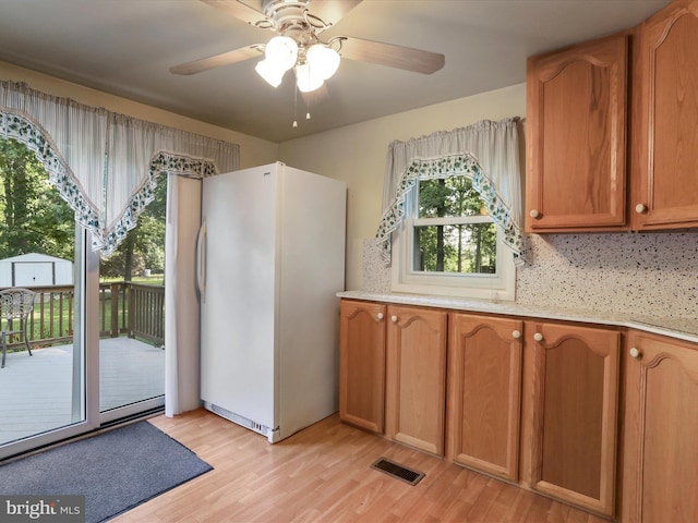 18540 Brooke Rd, Sandy Spring, MD 20860 - kitchen featuring freestanding refrigerator, light wood-type flooring, brown cabinetry, light countertops, and a ceiling fan