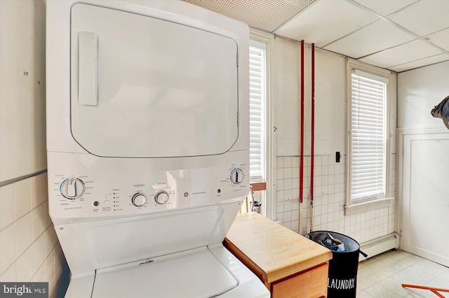 70 N Main St, Spring Grove, PA 17362 - laundry area featuring stacked washer and clothes dryer, a baseboard heating unit, and tile walls