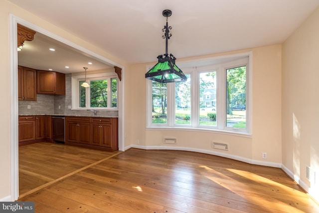 1901 Acorn Ln, Abington, PA 19001 - kitchen with light wood finished floors, brown cabinets, light stone countertops, and backsplash