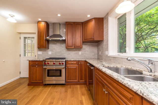 1901 Acorn Ln, Abington, PA 19001 - kitchen with wall chimney exhaust hood, appliances with stainless steel finishes, a sink, brown cabinets, and light wood-style flooring