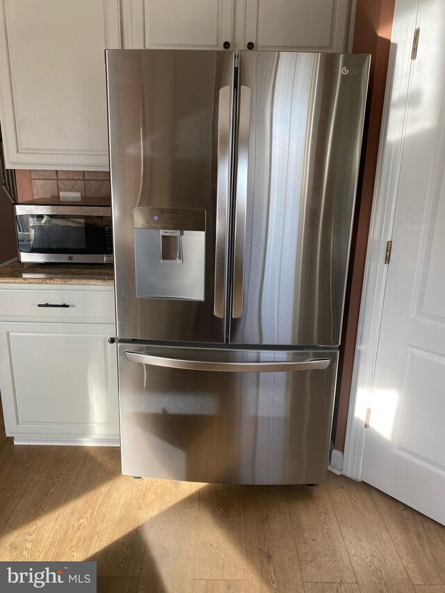 3313 Castle Ridge Cir, Silver Spring, MD 20904 - detailed view of appliances with stainless steel finishes, light wood-type flooring, white cabinets, and dark countertops