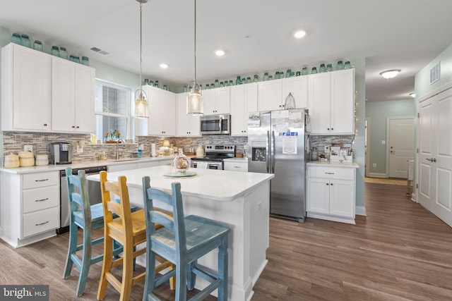 401 Bold Ruler Ct Unit 302, Havre De Grace, MD 21078 - kitchen with stainless steel appliances, decorative backsplash, white cabinetry, dark wood-type flooring, and a kitchen breakfast bar