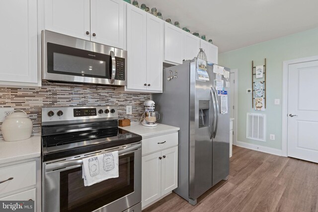 401 Bold Ruler Ct Unit 302, Havre De Grace, MD 21078 - kitchen featuring appliances with stainless steel finishes, light countertops, backsplash, light wood-style floors, and white cabinetry