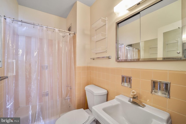 2475 Virginia Ave NW Unit 930, Washington, DC 20037 - bathroom with tile walls, shower / bath combo with shower curtain, and a wainscoted wall