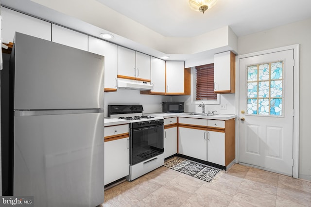 1238 Durfor St, Philadelphia, PA 19148 - kitchen with freestanding refrigerator, white range with gas stovetop, under cabinet range hood, black microwave, and light countertops
