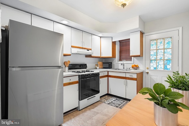 1238 Durfor St, Philadelphia, PA 19148 - kitchen featuring freestanding refrigerator, under cabinet range hood, white range with gas cooktop, light countertops, and white cabinets