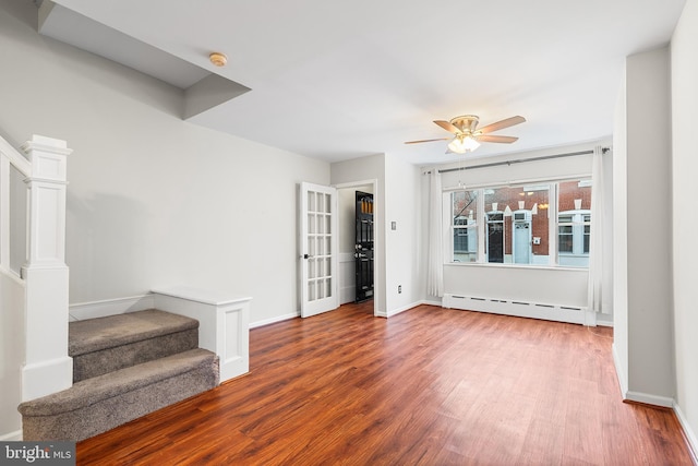 1238 Durfor St, Philadelphia, PA 19148 - unfurnished living room with a baseboard heating unit, stairs, wood finished floors, and ceiling fan