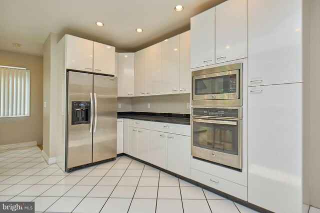 3820 Lorcom Ln, Arlington, VA 22207 - kitchen with appliances with stainless steel finishes, white cabinetry, dark countertops, recessed lighting, and baseboards