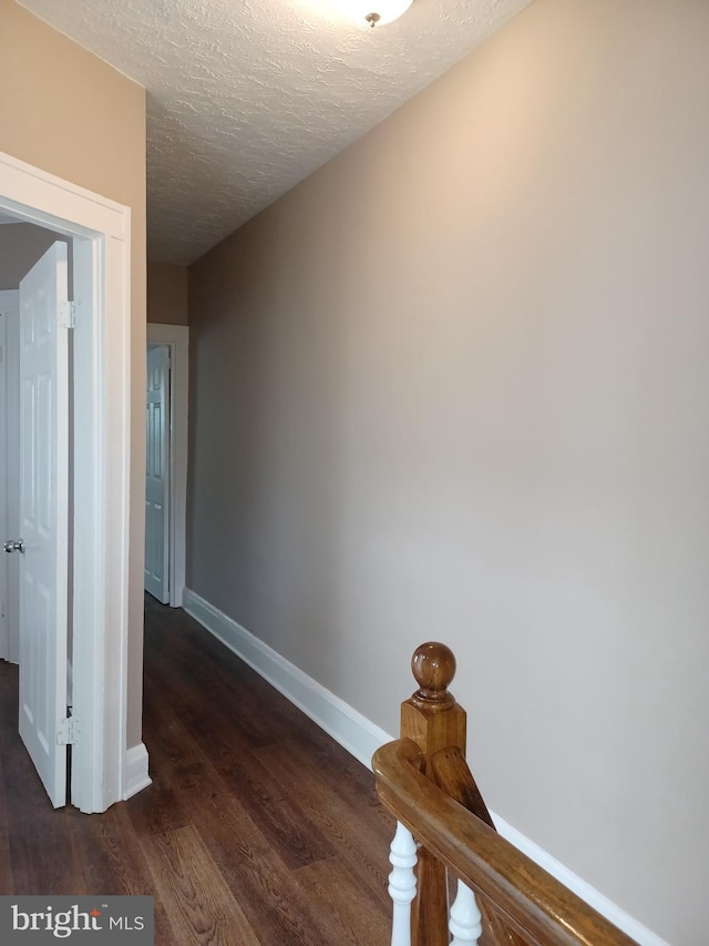 513 N Highland Ave, Baltimore, MD 21205 - hall with dark wood-style flooring, baseboards, and a textured ceiling