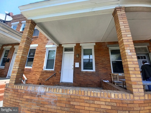 513 N Highland Ave, Baltimore, MD 21205 - view of exterior entry with a porch and brick siding
