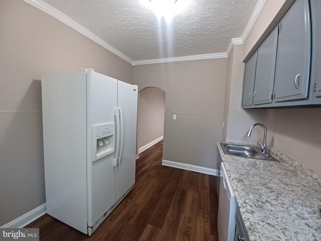 513 N Highland Ave, Baltimore, MD 21205 - kitchen with white refrigerator with ice dispenser, a sink, a textured ceiling, arched walkways, and dark wood-type flooring