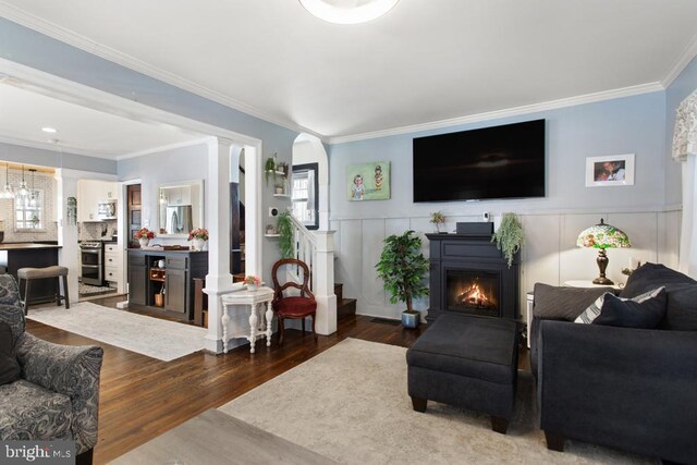 86 Greenfield Ave, Ardmore, PA 19003 - living area with wood finished floors, a warm lit fireplace, ornamental molding, a wainscoted wall, and a decorative wall