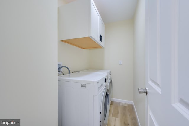 9708 Martinsburg Rd, Hedgesville, WV 25427 - washroom featuring light wood-style floors, washing machine and clothes dryer, baseboards, and cabinet space