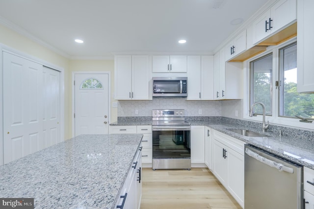 9708 Martinsburg Rd, Hedgesville, WV 25427 - kitchen featuring stainless steel appliances, a sink, white cabinetry, backsplash, and crown molding