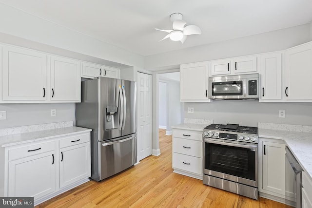 9416 Seven Courts Dr, Baltimore, MD 21236 - kitchen featuring appliances with stainless steel finishes, white cabinets, light wood-style flooring, ceiling fan, and light stone counters