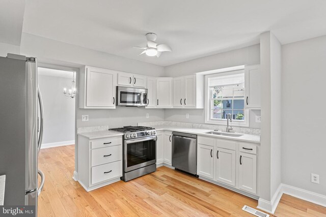 9416 Seven Courts Dr, Baltimore, MD 21236 - kitchen featuring stainless steel appliances, a sink, white cabinets, ceiling fan, and light countertops