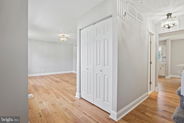 9416 Seven Courts Dr, Baltimore, MD 21236 - hall featuring a chandelier, light wood-type flooring, and baseboards