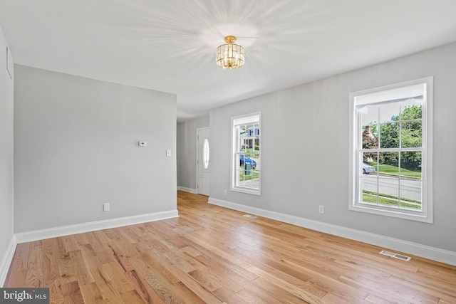 9416 Seven Courts Dr, Baltimore, MD 21236 - empty room featuring a chandelier, light wood finished floors, and baseboards