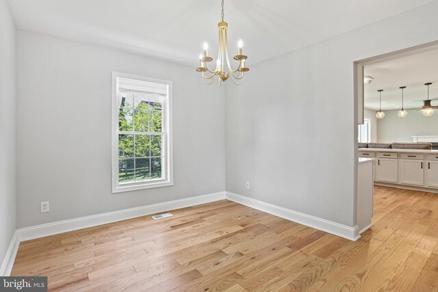 9416 Seven Courts Dr, Baltimore, MD 21236 - unfurnished dining area featuring a chandelier, light wood-style flooring, and baseboards