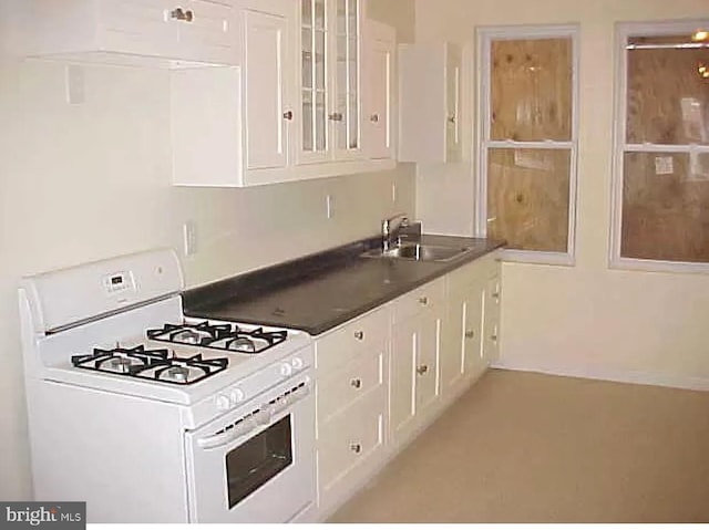 420 N Glover St, Baltimore, MD 21224 - kitchen with white gas stove, white cabinets, dark countertops, and glass insert cabinets