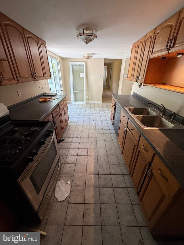 42264 Ridge Rd, Mechanicsville, MD 20659 - kitchen featuring stainless steel gas stove, a sink, dark countertops, brown cabinets, and tile patterned floors