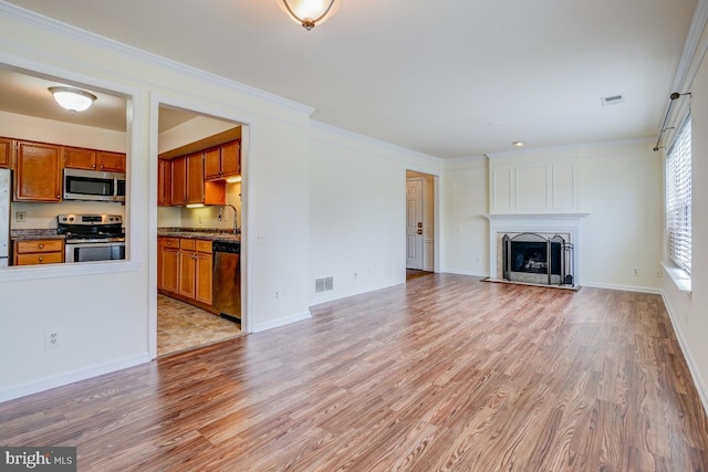 8064 Stonewall Brigade Ct, Manassas, VA 20109 - unfurnished living room featuring light wood finished floors, a sink, a fireplace, crown molding, and baseboards