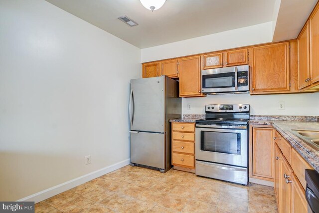 8064 Stonewall Brigade Ct, Manassas, VA 20109 - kitchen with appliances with stainless steel finishes, baseboards, and brown cabinetry