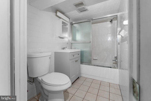2808 Presstman St, Baltimore, MD 21216 - bathroom featuring vanity, toilet, bath / shower combo with glass door, tile patterned floors, and a textured ceiling