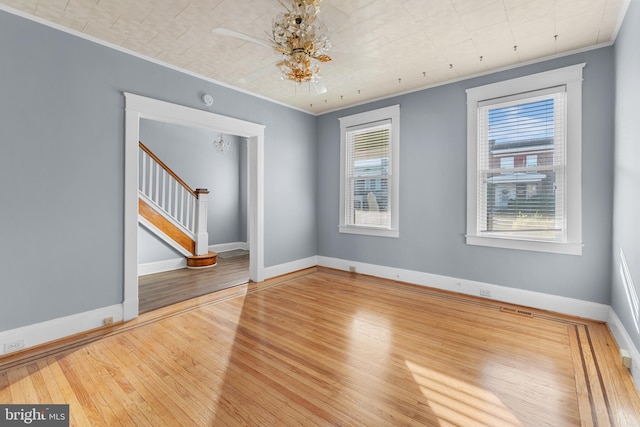 2808 Presstman St, Baltimore, MD 21216 - unfurnished room with stairway, hardwood / wood-style flooring, ornamental molding, a chandelier, and baseboards