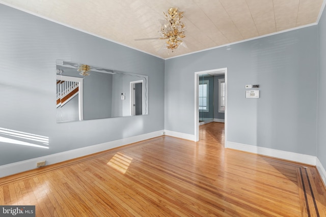 2808 Presstman St, Baltimore, MD 21216 - empty room with wood finished floors, baseboards, ornamental molding, and a chandelier