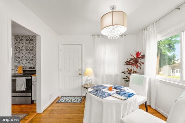 206 Mountain Rd, Linthicum Heights, MD 21090 - dining area with light wood-style floors, a chandelier, and baseboards