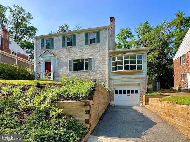 213 Dale Dr, Silver Spring, MD 20910 - colonial home with an attached garage, driveway, a chimney, and brick siding