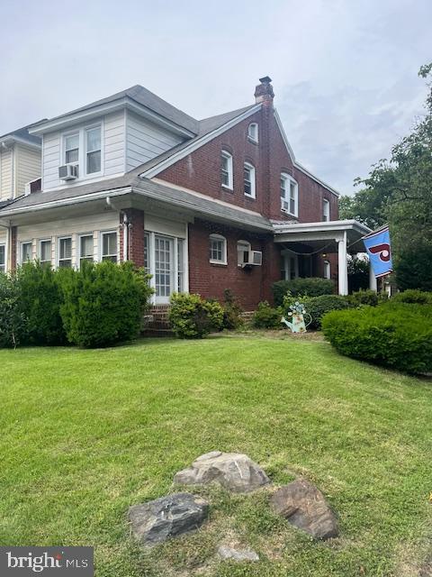 4327 Disston St, Philadelphia, PA 19135 - view of side of home featuring a yard, brick siding, and a chimney