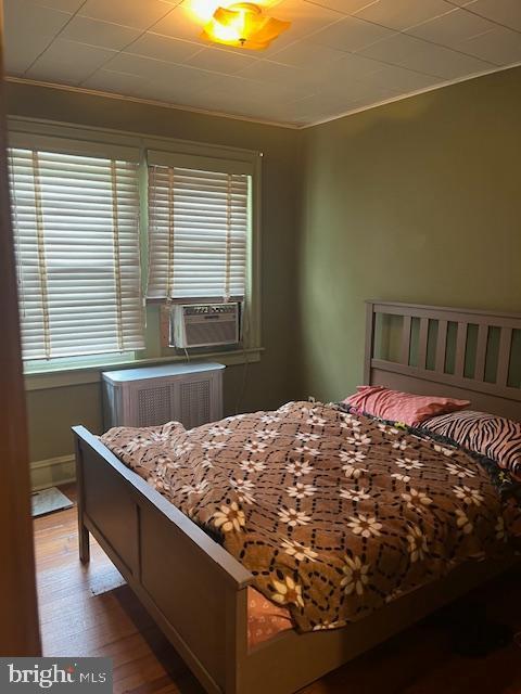 4327 Disston St, Philadelphia, PA 19135 - bedroom featuring multiple windows, cooling unit, wood finished floors, ornamental molding, and radiator